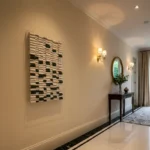 Minimalist abstract hand-painted canvas in cream, black and natural tones with geometric composition, contemporary entryway
