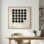 Minimalist hand-painted canvas featuring grid of black rounded squares with delicate drip details on textured cream background, contemporary workspace