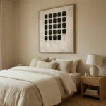 Minimalist hand-painted canvas with grid of black textured squares on cream background, contemporary bedroom