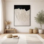 Textured abstract hand-painted canvas depicting snow-capped mountains against dark sky in cream and white, minimalist interior