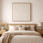 Textured minimalist hand-painted canvas with geometric diamond patterns in soft cream tones, styled in modern bedroom