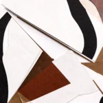 Layered abstract hand-painted canvas in terracotta, cream, black and tan geometric shapes, contemporary interior