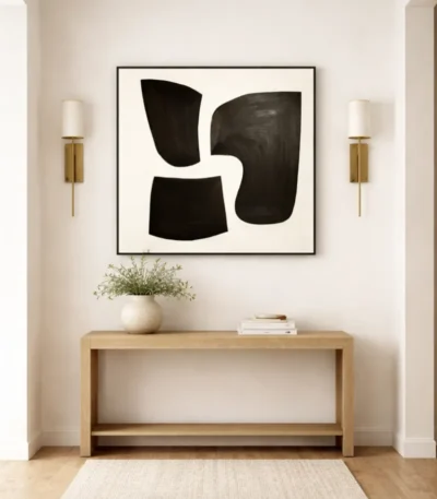 Minimalist abstract hand-painted canvas with bold black organic shapes on cream, contemporary entryway