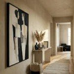 Minimalist abstract hand-painted canvas in black, cream, and grey geometric forms, contemporary hallway setting