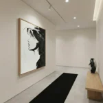 Monochromatic figurative hand-painted canvas depicting a woman's profile in bold black and white brushstrokes, contemporary gallery space
