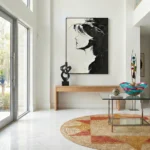Monochromatic figurative hand-painted canvas depicting a profile portrait in bold black and white gestural strokes, contemporary entryway