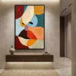 Abstract hand-painted canvas with bold geometric shapes in red, orange, blue, and cream tones, contemporary entryway