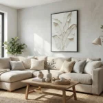Minimalist hand-painted canvas of layered botanical leaves in soft cream and beige tones, contemporary living space