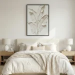 Textured minimalist hand-painted canvas depicting botanical leaves in layered cream and ivory tones, contemporary bedroom setting