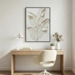 Textured minimalist hand-painted canvas depicting layered botanical leaves in soft cream and ivory tones, styled in contemporary workspace