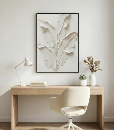Textured minimalist hand-painted canvas depicting layered botanical leaves in soft cream and ivory tones, styled in contemporary workspace