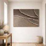 Textured abstract hand-painted canvas with layered torn paper effect in warm taupe and cream tones, modern entryway