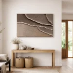 Textured abstract hand-painted canvas depicting layered ocean waves in warm beige and taupe tones, contemporary entryway