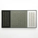 Minimalist hand-painted canvas featuring grid of cream circles on black, grey, and white panels, contemporary interior