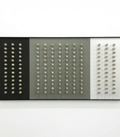 Minimalist hand-painted canvas featuring grid of cream circles on black, grey, and white panels, contemporary interior