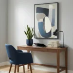 Minimalist abstract hand-painted canvas with layered geometric shapes in navy, cream, and grey tones, contemporary workspace