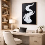 Gestural abstract hand-painted canvas in monochrome black and white with flowing brushstrokes, contemporary workspace