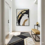 Gestural abstract hand-painted canvas with bold black and gold brushstrokes on cream, modern entryway