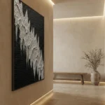 Textured abstract hand-painted canvas in monochrome black and white with layered relief details, contemporary gallery space