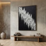 Textured abstract hand-painted canvas depicting white jagged peaks against dark rippled background, monochrome palette, contemporary interior