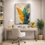 Contemporary hand-painted canvas depicting stylized feathers in golden yellow, teal, and cream tones, modern office space