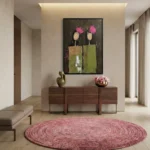 Gestural abstract hand-painted canvas depicting two figures with pink floral heads in muted greens and blacks, entryway setting