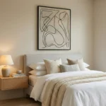 Minimalist black ink line drawing on cream canvas with gestural abstract forms, styled in a contemporary bedroom