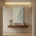 Textured abstract hand-painted canvas with layered white relief forms and subtle grey tones, contemporary entryway