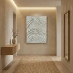 Textured abstract hand-painted canvas with layered grey and white wavy patterns, neutral palette, contemporary hallway