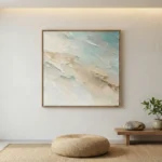Textured abstract hand-painted canvas in soft cream, sage, and pale blue tones with gestural brushwork, contemporary minimalist space
