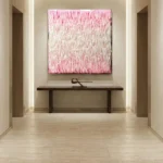 Textured abstract hand-painted canvas in soft pink and cream brushstrokes, contemporary hallway setting