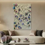 Textured abstract hand-painted canvas with iridescent circular forms in jewel tones against rippled cream background, contemporary living space
