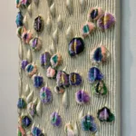 Textured abstract hand-painted canvas with multicolored fuzzy three-dimensional forms on cream ribbed background, contemporary wall space
