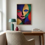 Contemporary abstract hand-painted canvas depicting stylized face in bold jewel tones and black outlines, modern workspace