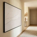 Minimalist textured hand-painted canvas depicting abstract sandy dunes in cream and ivory tones, contemporary hallway