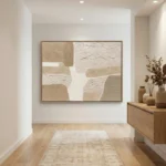Textured abstract hand-painted canvas in layered cream and sand tones with gestural brushwork, contemporary entryway