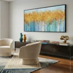 Layered abstract hand-painted canvas in golden ochre and soft blue tones with gestural drip details, contemporary living space