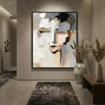 Gestural abstract hand-painted canvas with expressive brushstrokes in cream, ochre and charcoal tones, modern entryway