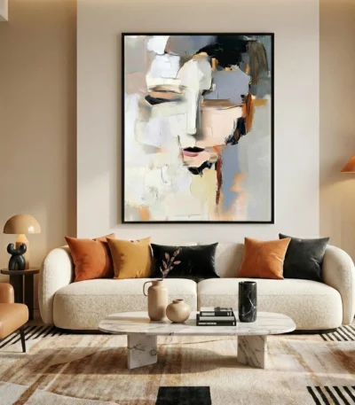 Abstract expressionist hand-painted canvas depicting a stylized face in cream, black, and ochre tones, contemporary living space