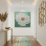 Textured contemporary hand-painted canvas depicting white flower with gold center on vibrant turquoise background, modern entryway