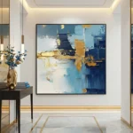 Abstract expressionist hand-painted canvas with layered blue, gold, and white gestural brushstrokes, contemporary entryway