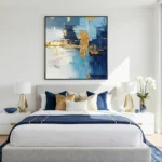 Gestural abstract hand-painted canvas in layered blues, golds, and cream with dynamic brushwork, modern bedroom setting