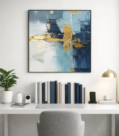 Layered abstract hand-painted canvas in soft blues, golds, and navy with gestural brushstrokes, styled in a contemporary workspace