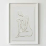 Minimalist hand-painted canvas depicting a seated female figure in textured white relief, contemporary living space