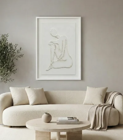 Minimalist hand-painted canvas depicting an abstracted seated figure in soft cream and white tones, contemporary living space