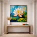 Contemporary hand-painted canvas depicting a blooming lotus flower in white, coral and yellow against textured blue-green water, modern entryway