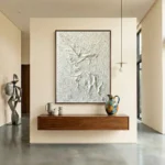 Textured abstract hand-painted canvas with sculptural white relief and gestural forms in monochrome, contemporary entryway