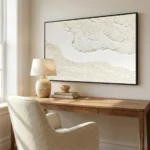 Textured abstract hand-painted canvas in cream and ivory with layered gestural marks, contemporary workspace