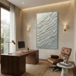 Textured abstract hand-painted canvas with layered white and cream wave patterns, contemporary office setting