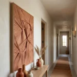 Textured abstract hand-painted canvas in terracotta and cream with radiating geometric fold patterns, hallway setting